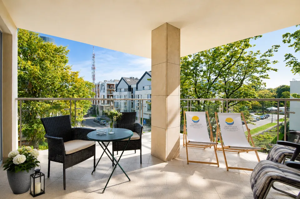 Duży taras apartamentu Avangard Family z leżakami i stolikiem