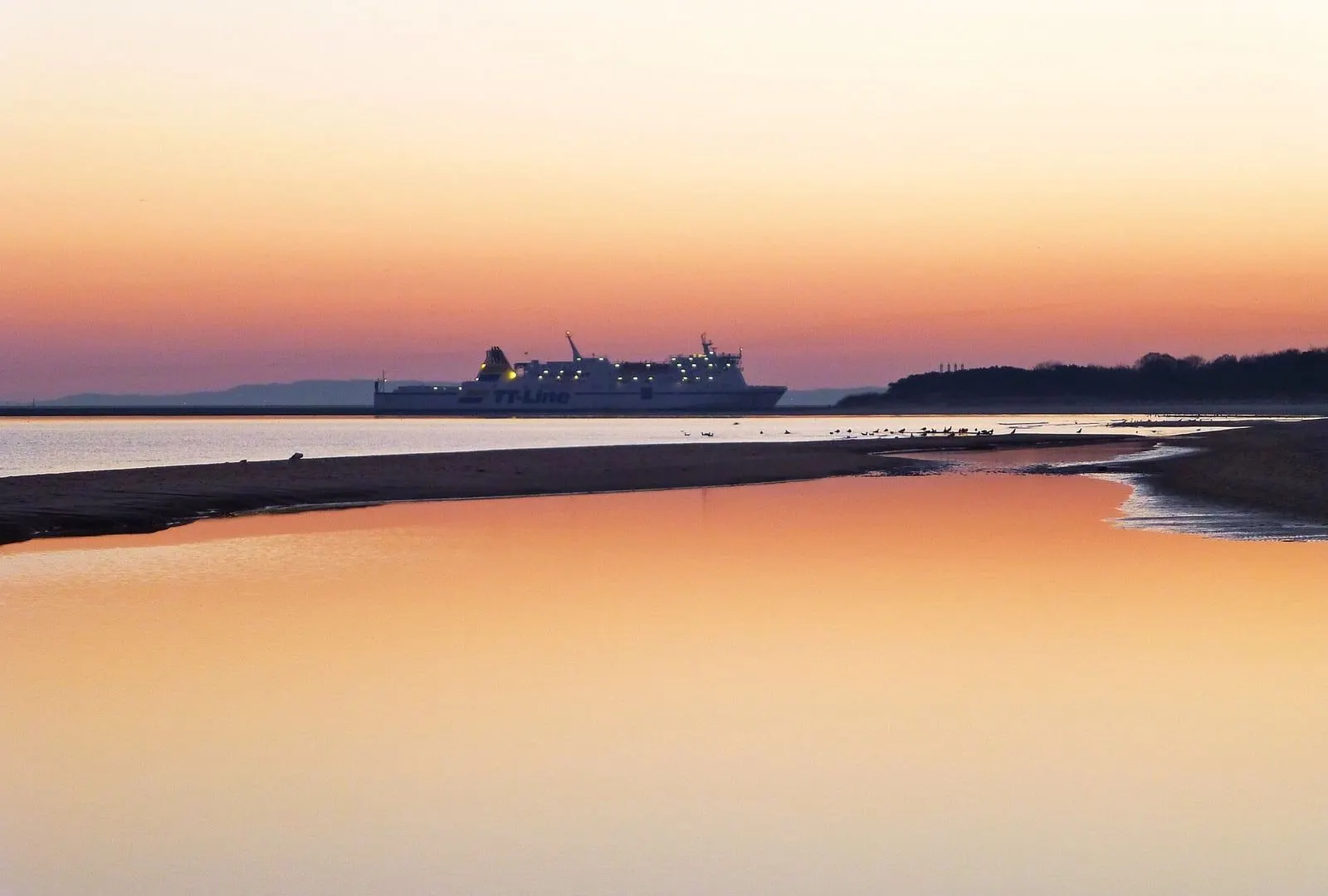 Plaża o świcie z promem na horyzoncie